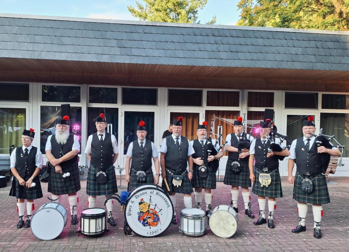 Schottische Musiker in traditioneller Kleidung mit Dudelsäcken und Trommeln.