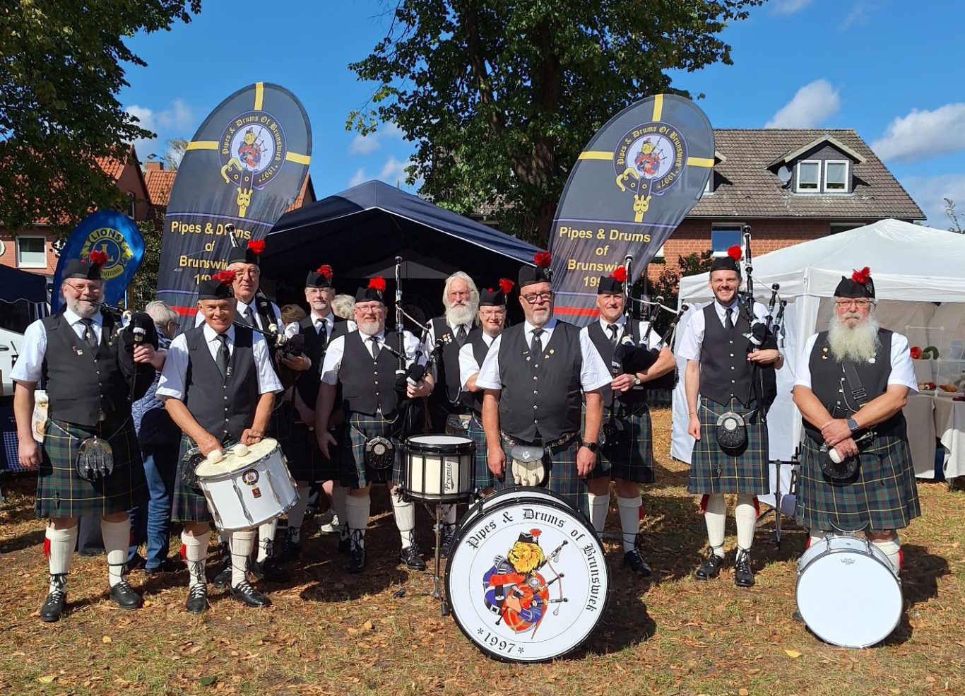 Schottische Musiker in traditioneller Kleidung mit Dudelsäcken und Trommeln.